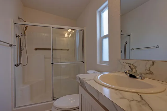 a bathroom with a sink toilet and shower