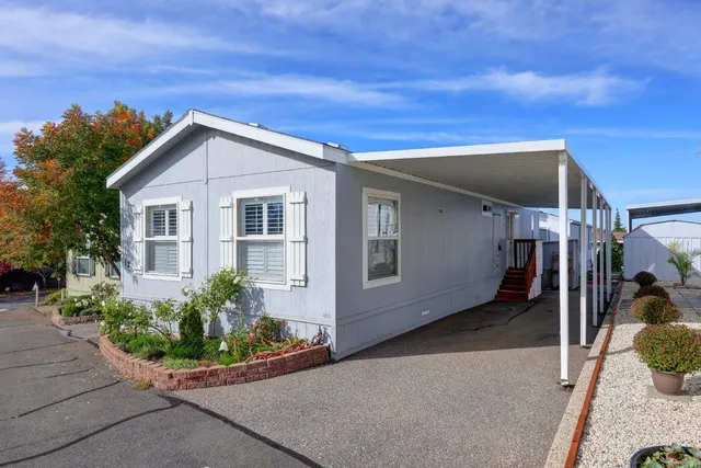 a view of a house with a small yard and potted plants