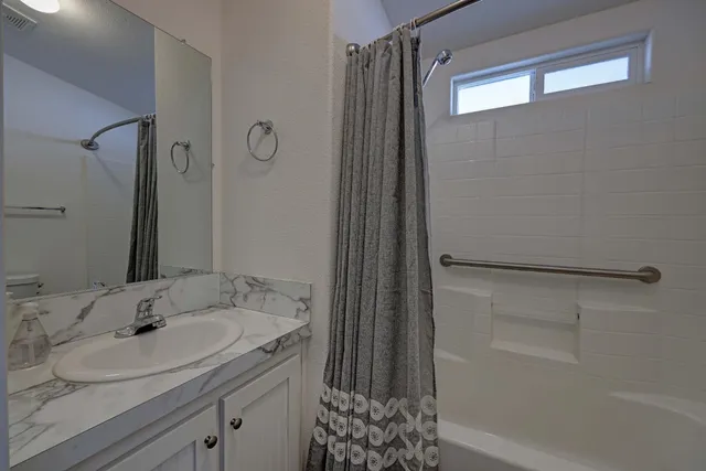 a bathroom with a granite countertop sink and a mirror