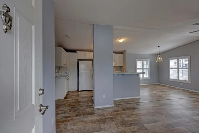 a view of livingroom with hardwood floor and a kitchen