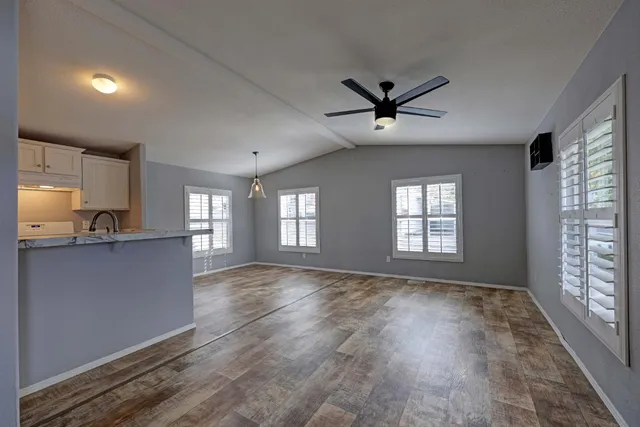a view of an empty room and window and wooden floor in a room