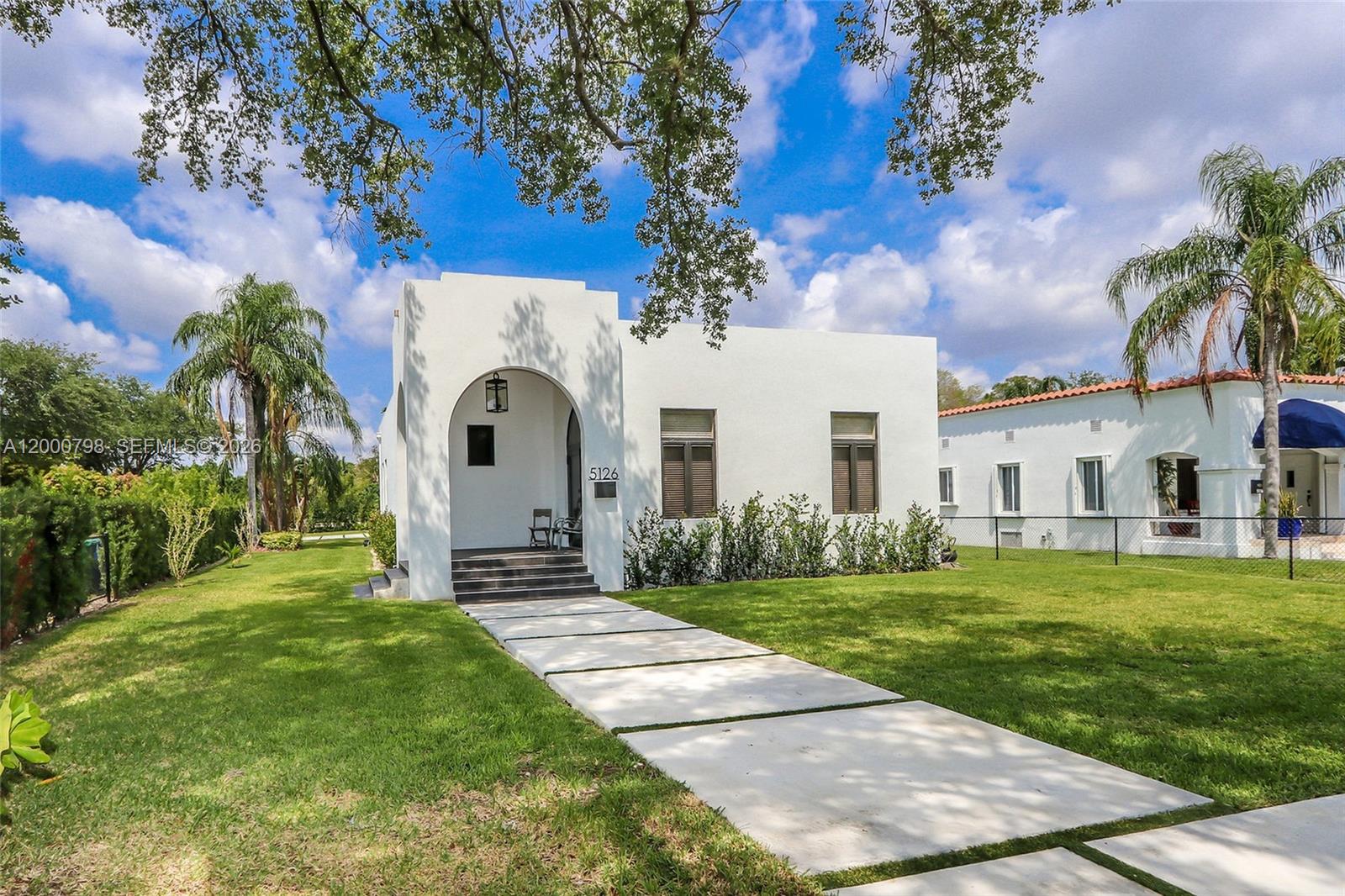 a front view of a house with a garden and yard