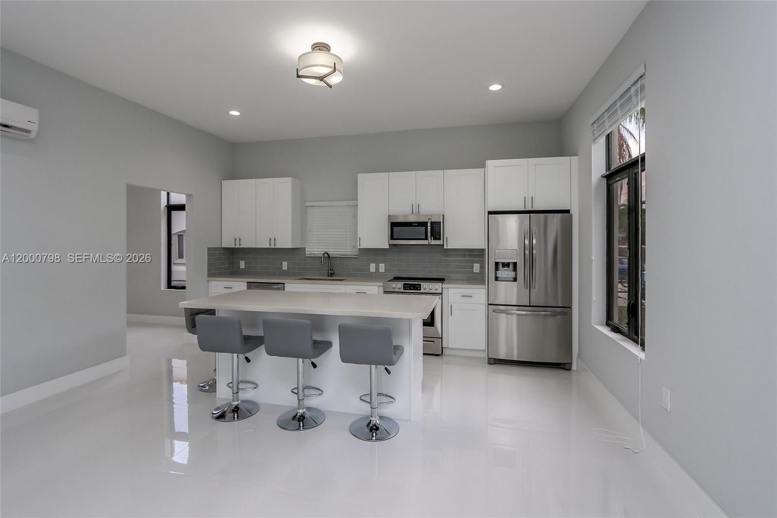 5126 Southwest 57th Avenue Miami, FL 33155 - Photo 9 of 32 a kitchen with stainless steel appliances a refrigerator sink and white cabinets