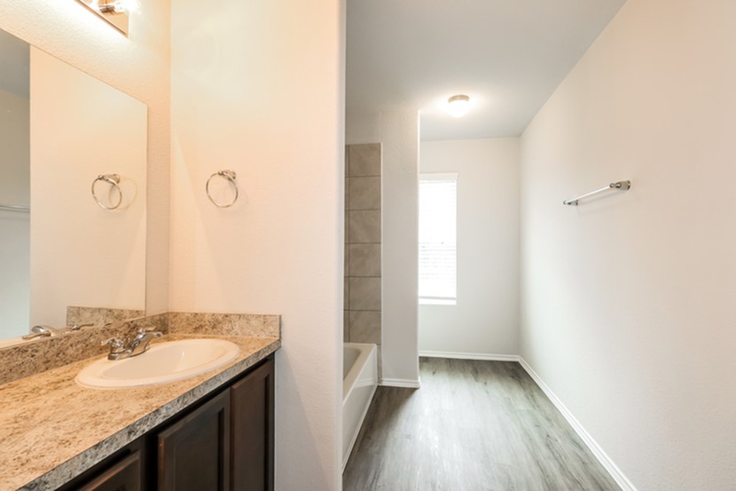 3745 Alexus Drive Conroe, TX 77301 - Photo 15 of 19 a bathroom with a granite countertop sink a toilet and a mirror