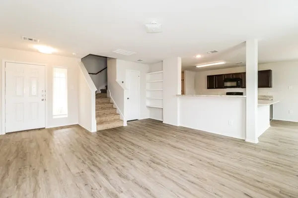 a view of a livingroom with wooden floor and staircase