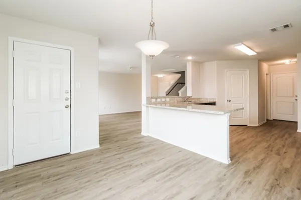 a view of kitchen with granite countertop cabinets and wooden floor