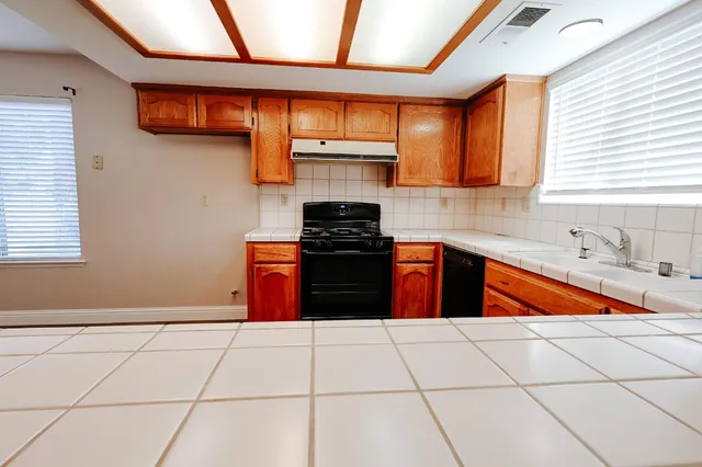 a kitchen with stainless steel appliances granite countertop a stove a sink and a microwave
