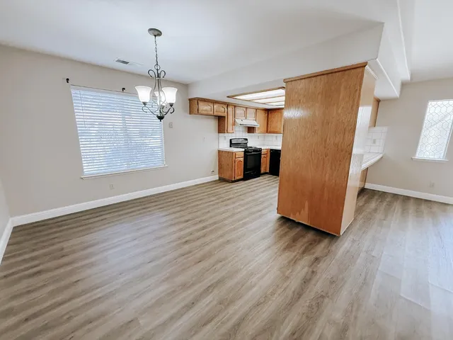 a view of a kitchen with a sink wooden floor and a refrigerator