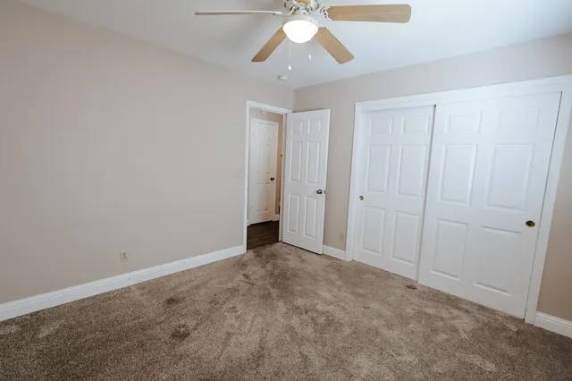 a view of an empty room and chandelier fan