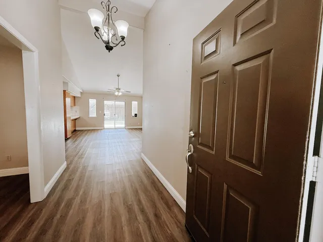 a view of a hallway with wooden floor and staircase