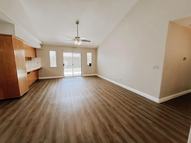a view of a room with wooden floor staircase and a kitchen space