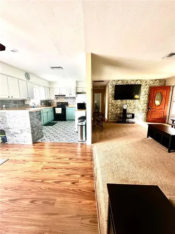 a view of a living room with kitchen island furniture and a kitchen view