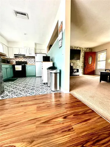 a view of a living room kitchen and a wooden floor