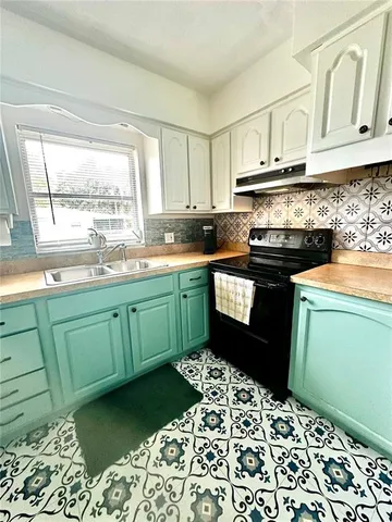 a kitchen with a sink stove and cabinets