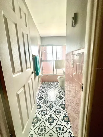 a view of a hallway with wooden floor and door