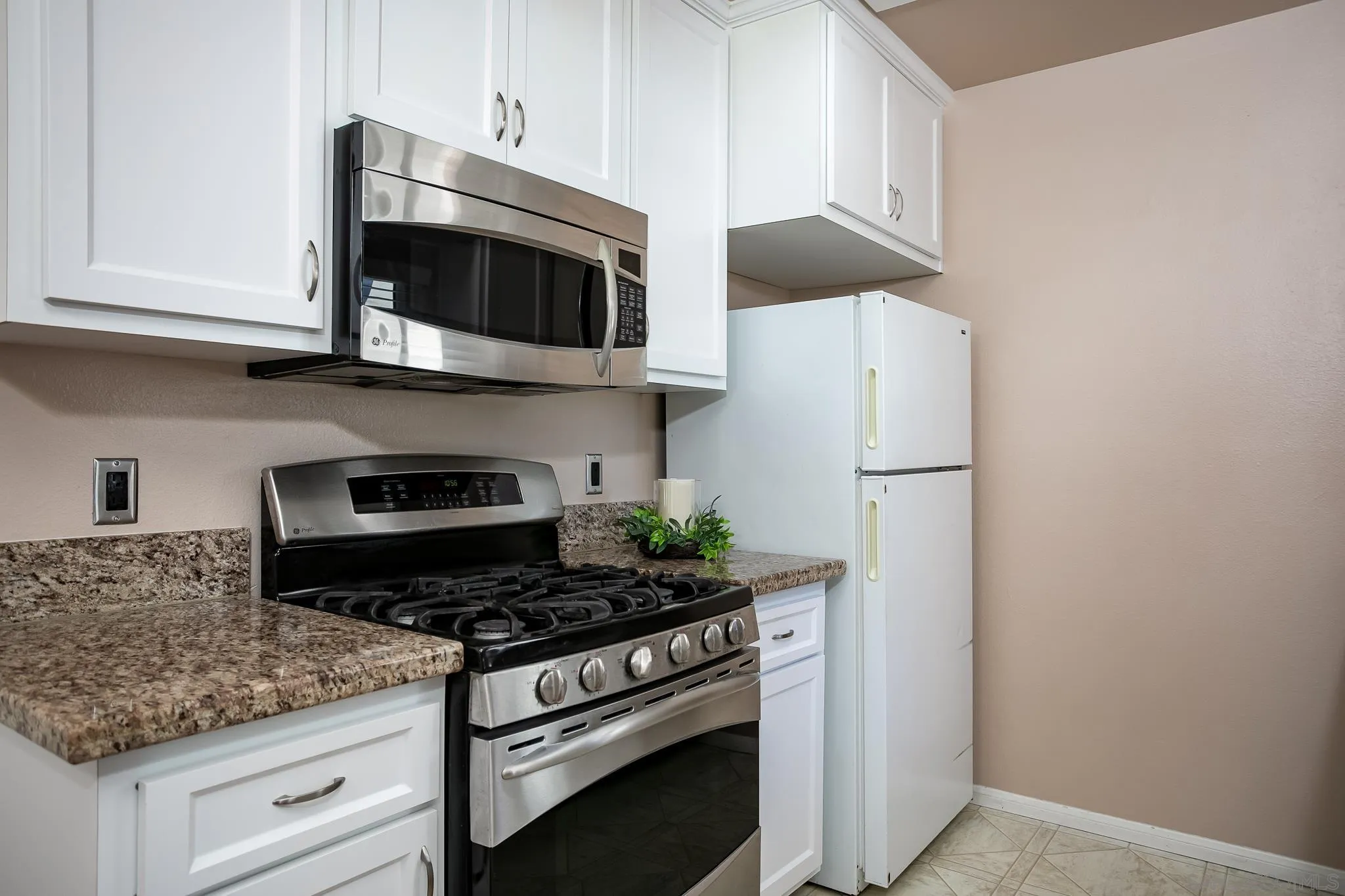 13816 Midland Road Poway, CA 92064 - Photo 8 of 37 a kitchen with stainless steel appliances granite countertop white cabinets a stove a microwave and a refrigerator
