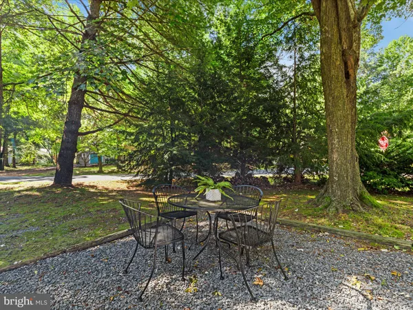 a view of a house with a yard and large trees