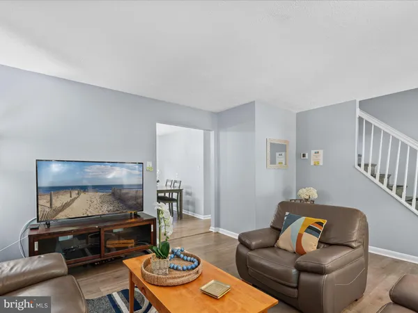 a living room with furniture a flat screen tv and a dining table with a bookshelf