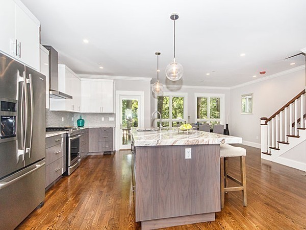 24-26 Beaconsfield Road, Unit 26 Brookline, MA 02445 - Photo 6 of 25 a kitchen with kitchen island a stove a sink a center island and a wooden floor