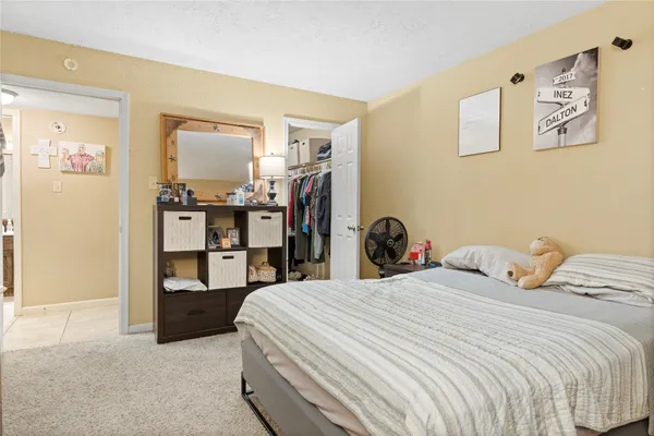 a bathroom with a granite countertop sink toilet a mirror and shower curtain