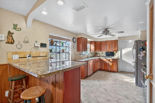 a kitchen with stainless steel appliances granite countertop a refrigerator and a stove top oven