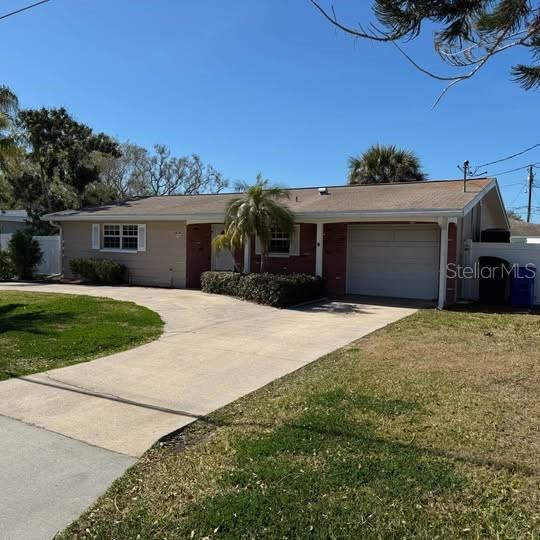 2154 Cedar Drive Dunedin, FL 34698 - Photo 2 of 19 a front view of a house with a yard and garage