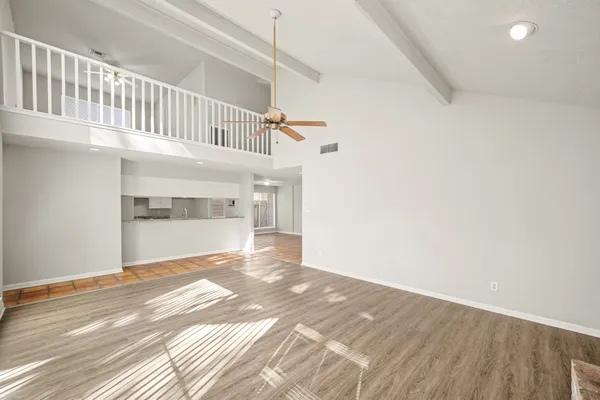 a view of a big room with wooden floor and staircase
