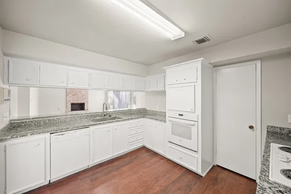 a kitchen with granite countertop white cabinets and white appliances