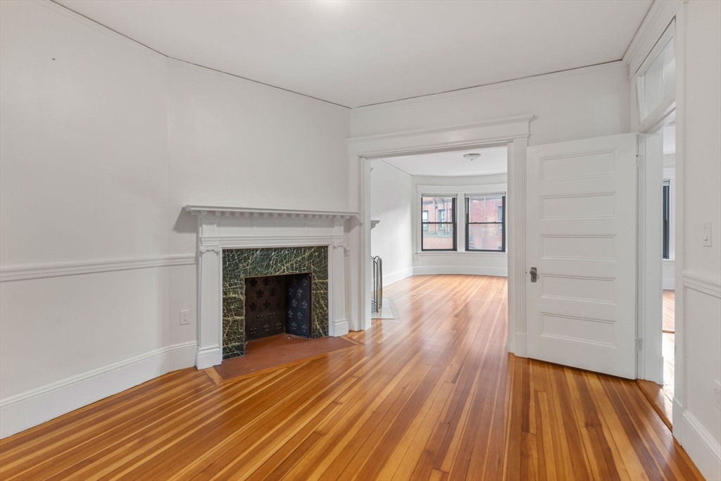 5 Winchester Street, Unit 201 Brookline, MA 02446 - Photo 1 of 14 a view of an empty room with wooden floor and a fireplace