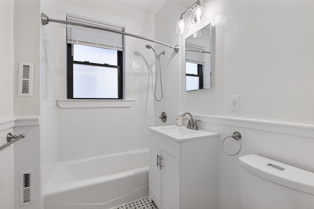 5 Winchester Street, Unit 201 Brookline, MA 02446 - Photo 12 of 14 a bathroom with a shower a sink and a mirror