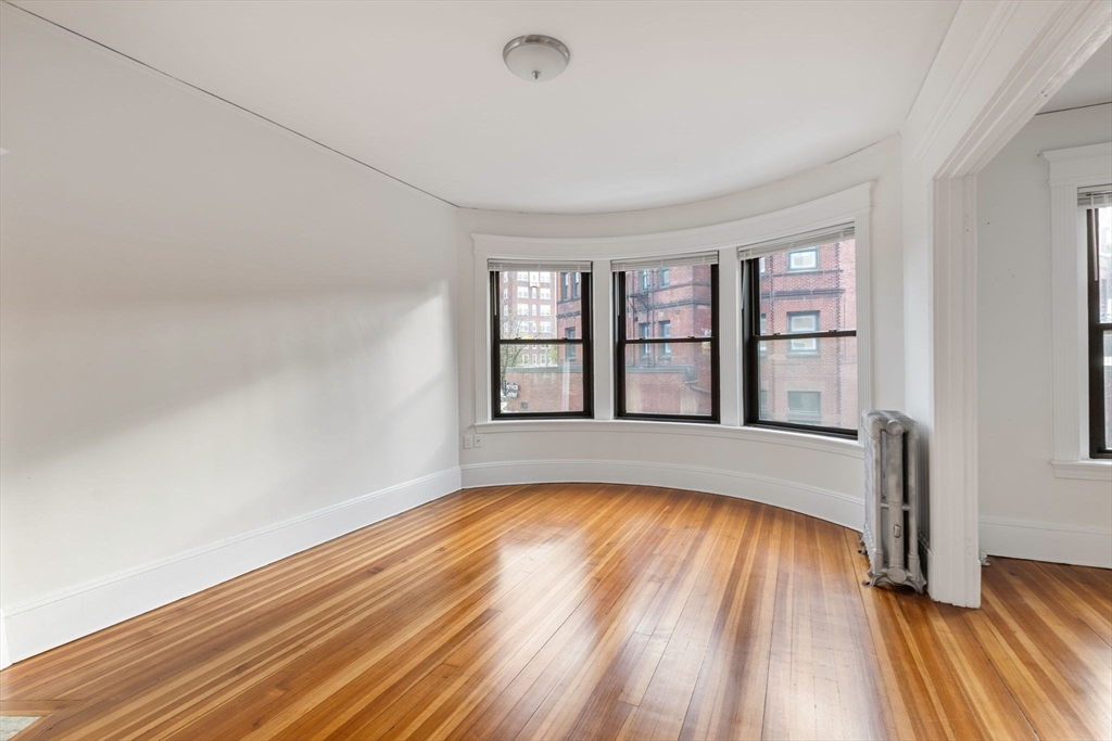 5 Winchester Street, Unit 201 Brookline, MA 02446 - Photo 3 of 14 a view of empty room with wooden floor and fan