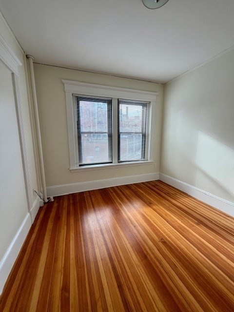 5 Winchester Street, Unit 201 Brookline, MA 02446 - Photo 10 of 14 a view of an empty room with wooden floor and window
