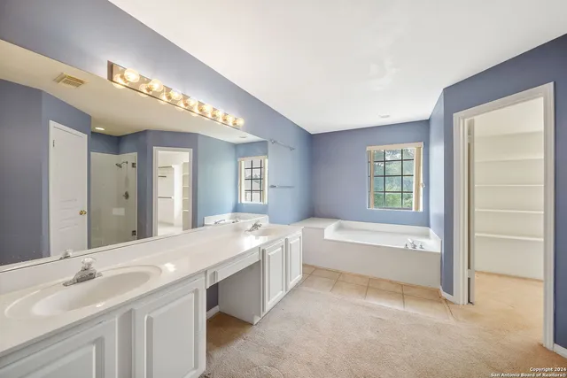 a spacious bathroom with a large tub sink and vanity