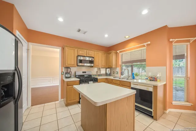 a kitchen with a stove a refrigerator and a sink