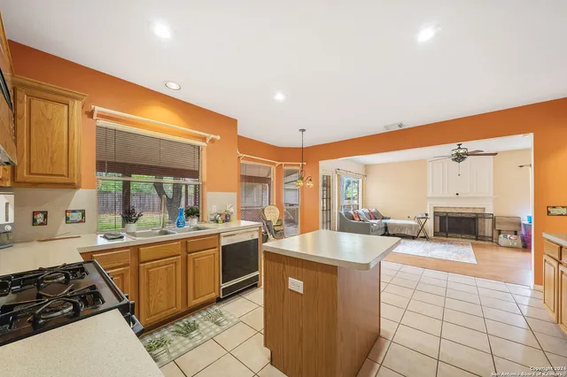 a large kitchen with stainless steel appliances a sink and cabinets