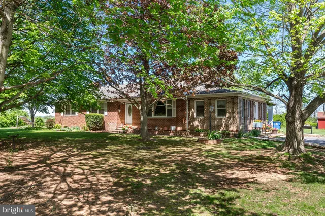 a dining room with furniture a chandelier and wooden floor