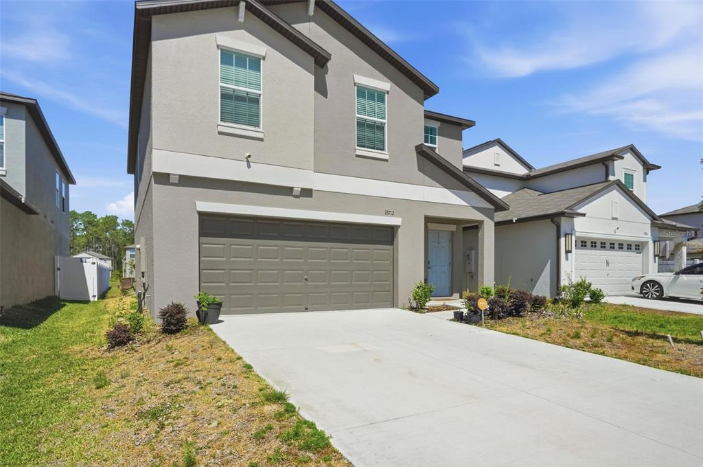 13712 Newbridge Street Spring Hill, FL 34609 - Photo 2 of 35 a front view of a house with a yard and garage