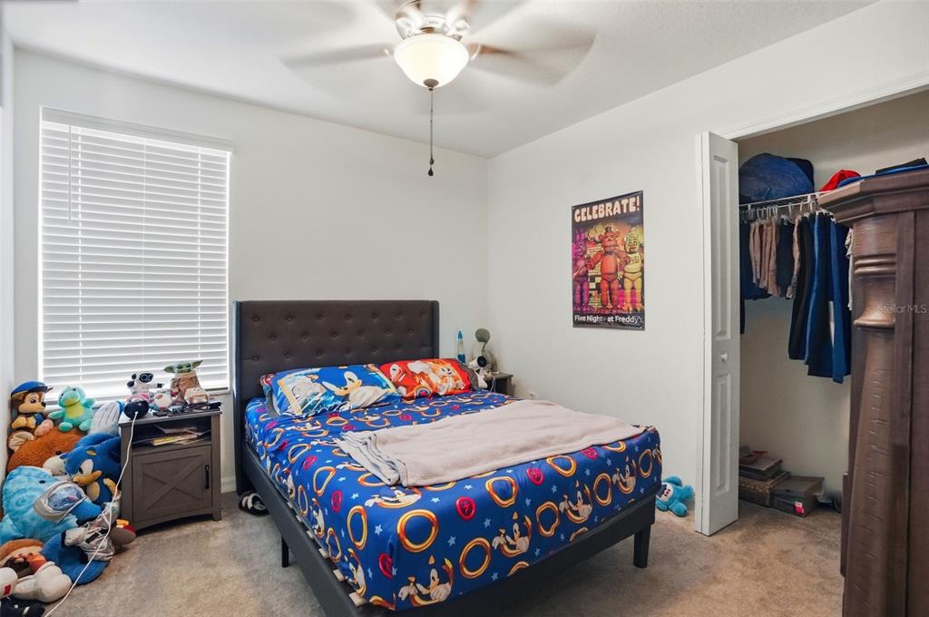 13712 Newbridge Street Spring Hill, FL 34609 - Photo 21 of 35 a bedroom with a bed and a chandelier