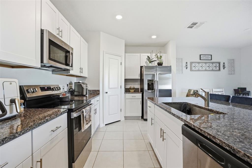 13712 Newbridge Street Spring Hill, FL 34609 - Photo 4 of 35 a kitchen with stainless steel appliances granite countertop a sink stove and refrigerator