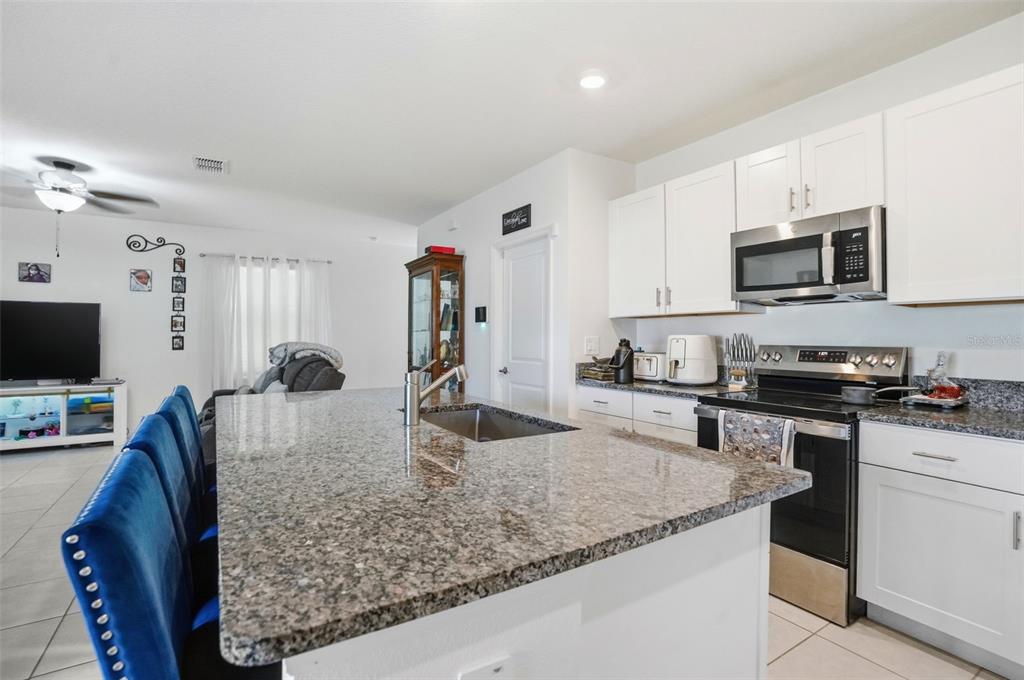 13712 Newbridge Street Spring Hill, FL 34609 - Photo 7 of 35 a kitchen with stainless steel appliances granite countertop a sink a stove and microwave