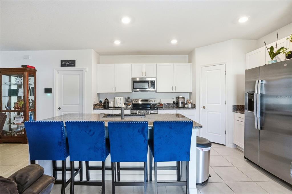 13712 Newbridge Street Spring Hill, FL 34609 - Photo 8 of 35 a kitchen with stainless steel appliances granite countertop a table chairs microwave and sink