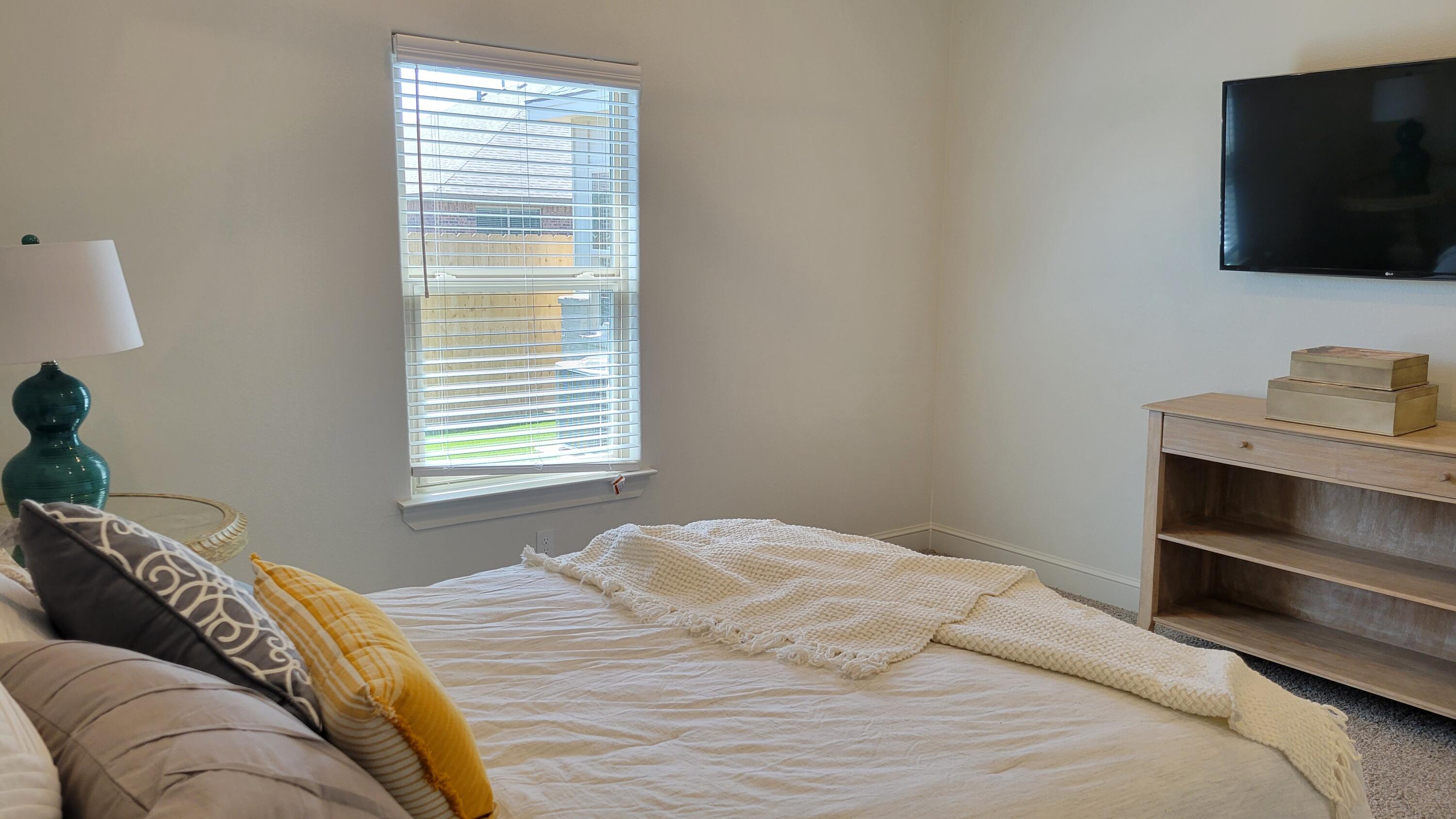 7120 22nd Street Lubbock, TX 79407 - Photo 21 of 40 a bedroom with a bed and a flat screen tv