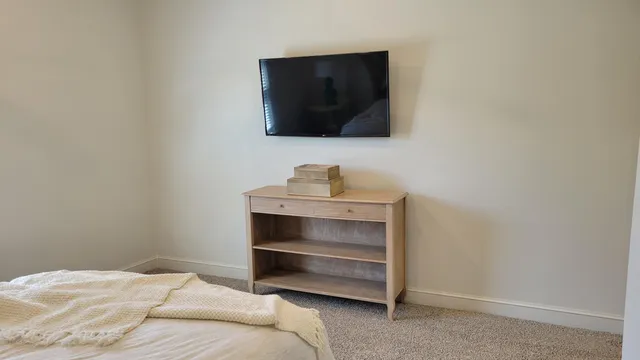 a bedroom with a bed and a flat screen tv