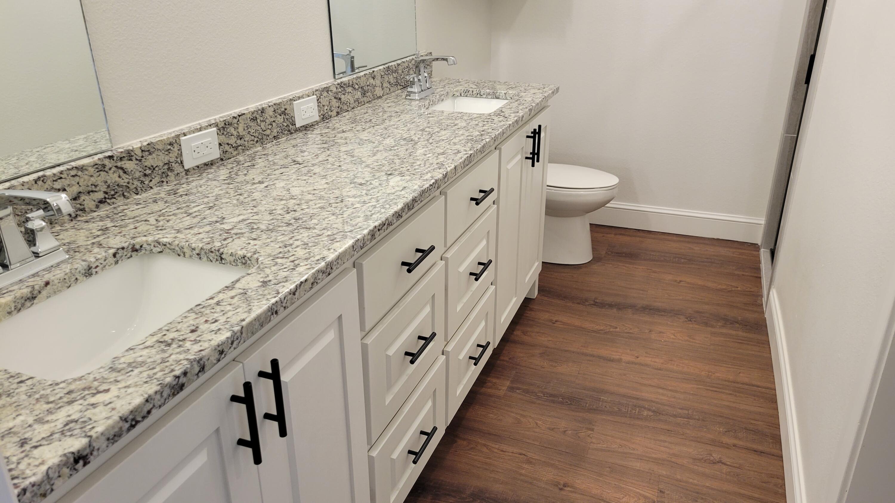 7120 22nd Street Lubbock, TX 79407 - Photo 23 of 40 a bathroom with a granite countertop sink and a toilet
