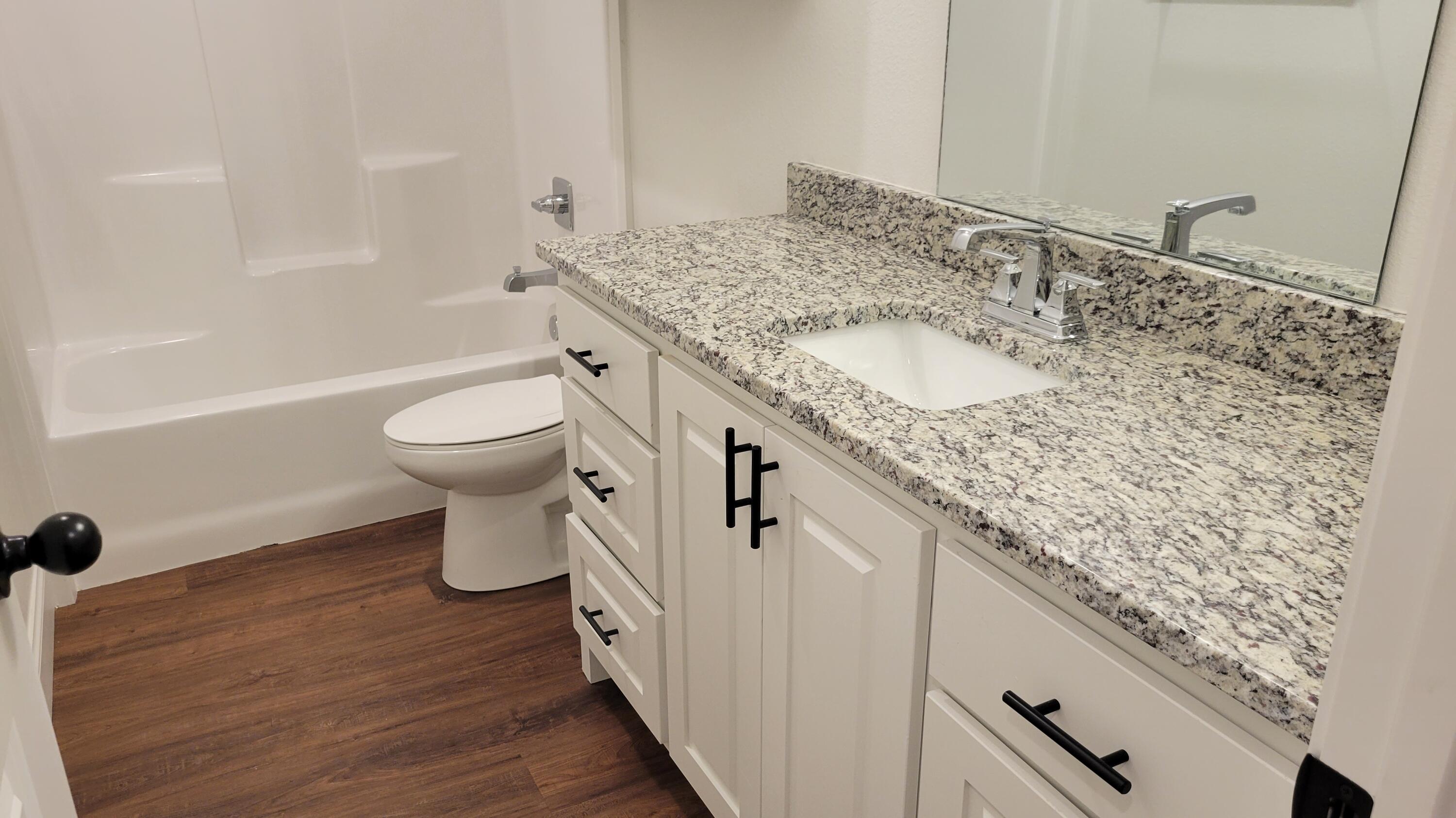 7120 22nd Street Lubbock, TX 79407 - Photo 30 of 40 a bathroom with a granite countertop sink and a mirror