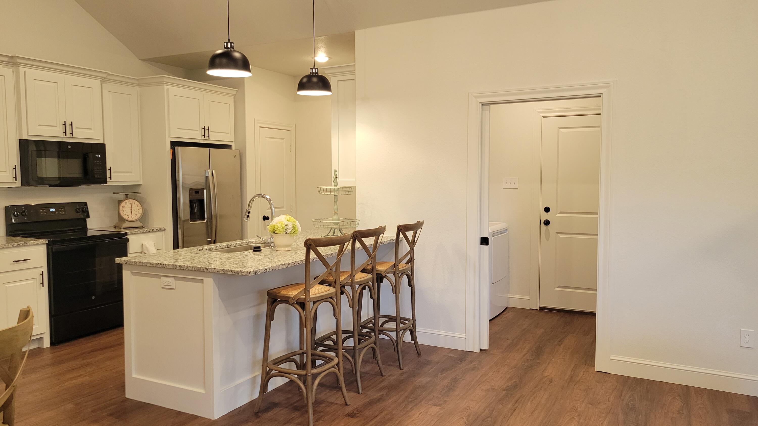 7120 22nd Street Lubbock, TX 79407 - Photo 7 of 40 a kitchen with stainless steel appliances a table chairs refrigerator and microwave