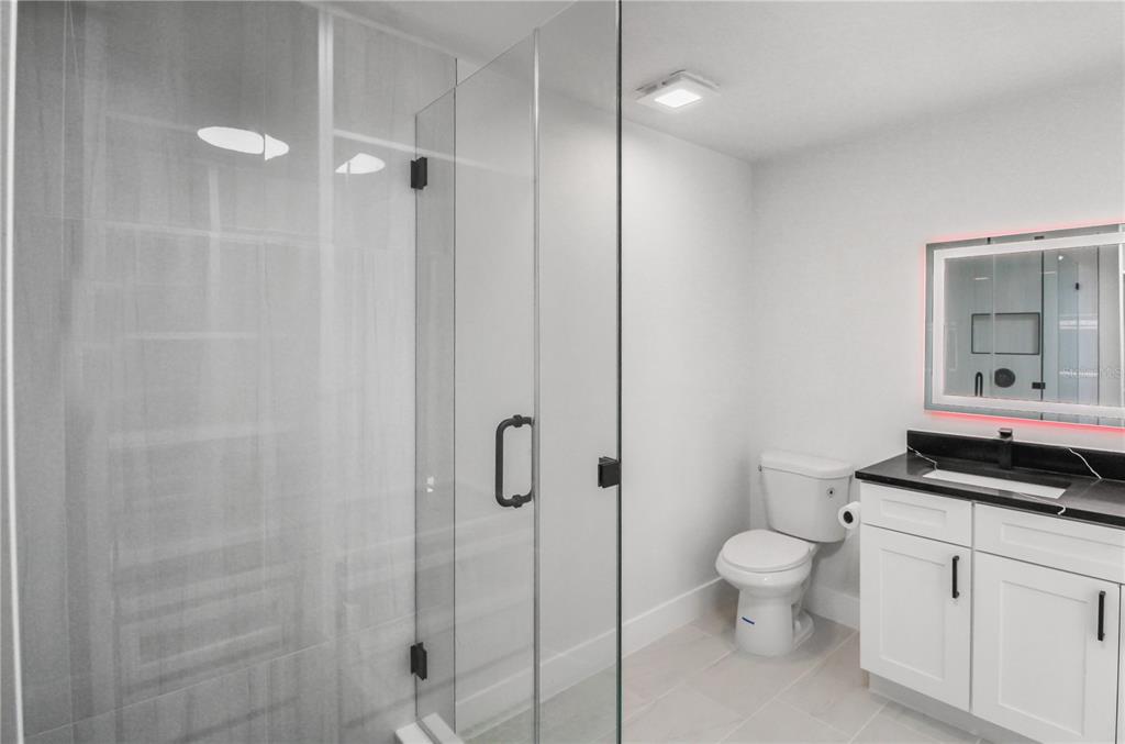 11492 93rd Street Largo, FL 33773 - Photo 13 of 37 a bathroom with a toilet a sink and shower