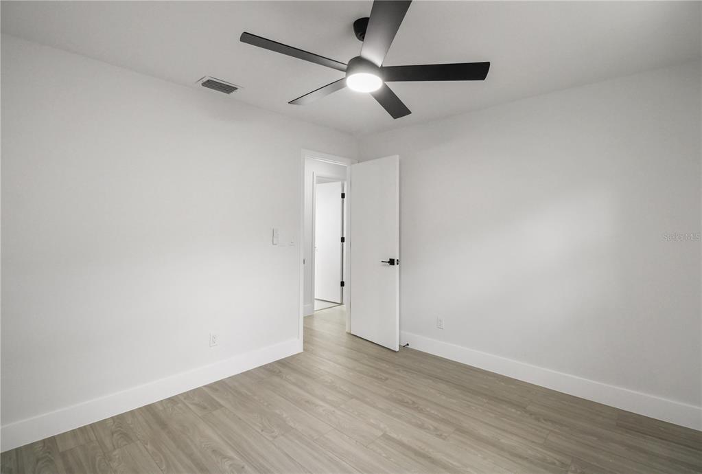 11492 93rd Street Largo, FL 33773 - Photo 20 of 37 an empty room with wooden floor and windows