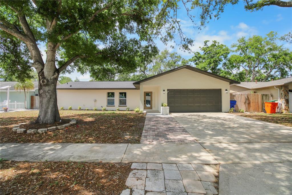 11492 93rd Street Largo, FL 33773 - Photo 2 of 37 a front view of a house with a yard and garage