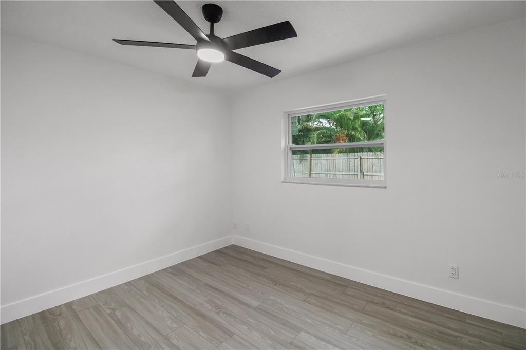 11492 93rd Street Largo, FL 33773 - Photo 26 of 37 an empty room with wooden floor and windows